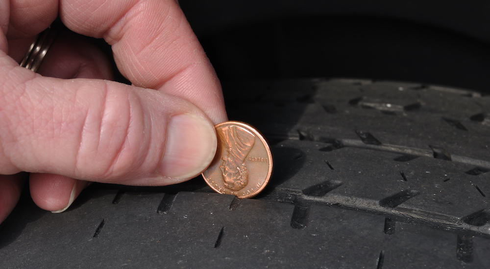 A penny being used to check a tire's treads