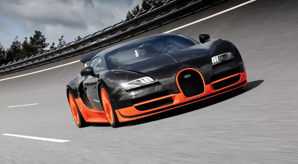 The most recent Bugatti Veyron 16.4 Super Sport, as of 2019, is shown in orange and grey on a track. Getting an oil change in Cincinnati on this would be extremely expensive. 