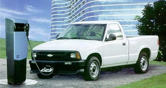 A white Chevy s10 plugged into a charging station