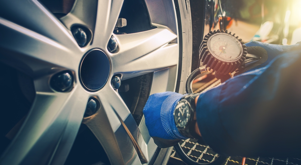 Checking tire pressure in the afternoon with a gauge