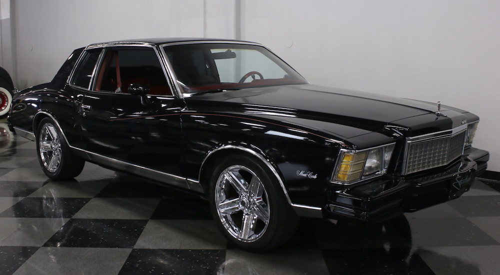 A black 1979 Chevy Monte Carlo is parked in a garage.
