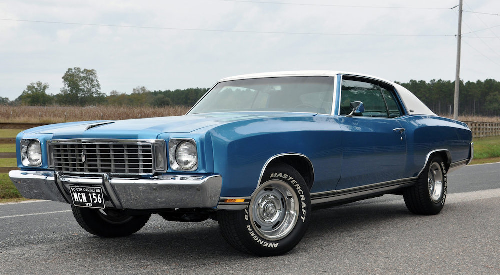 A blue mid 70s Chevy Monte Carlo is parked after leaving one of the local Chevy Dealerships.