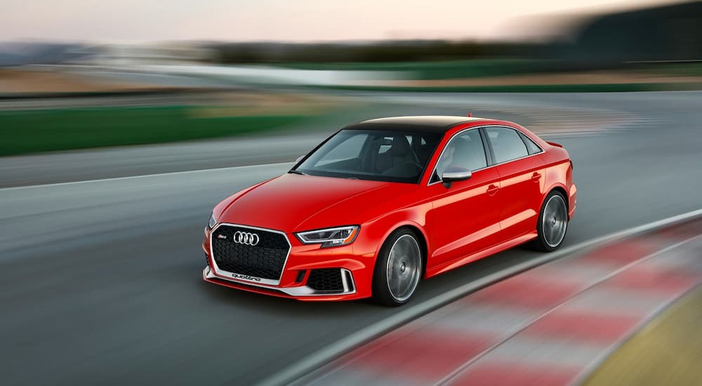 A red Audi RS3 is going around a track.