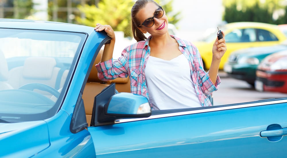 A woman happy with her new used car purchase