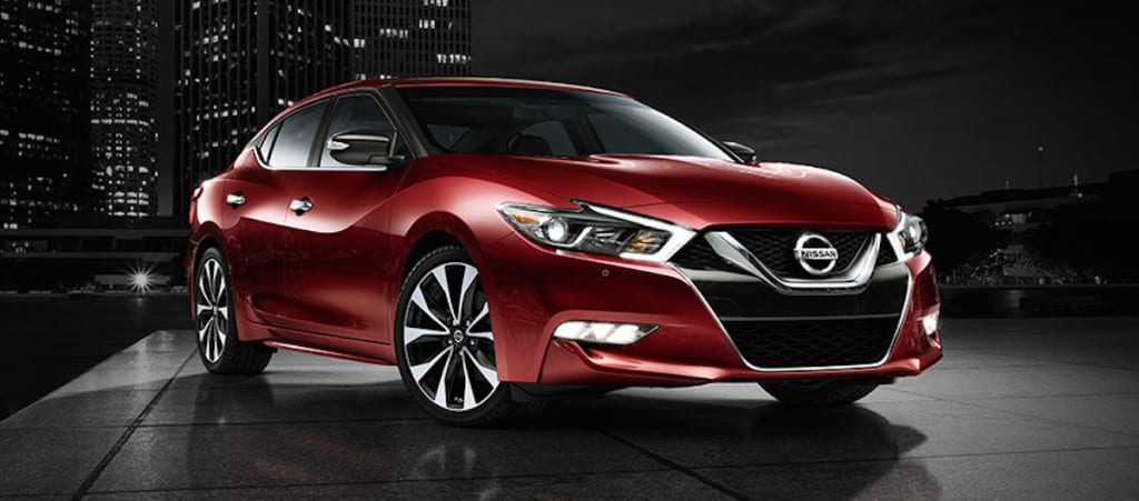 2016-nissan-maxima-coulis-red-side-view-night-skyline-next-steps
