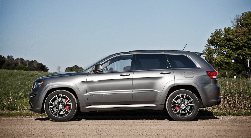 A silver 2012 Jeep Grand Cherokee SRT in front of a field