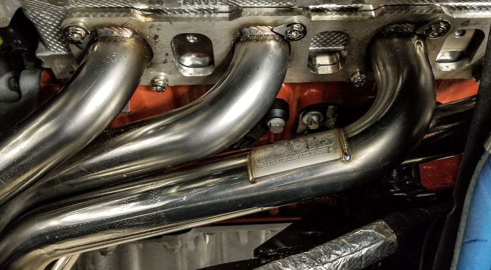 Aftermarket headers on a used Jeep Wrangler are shown in closeup.