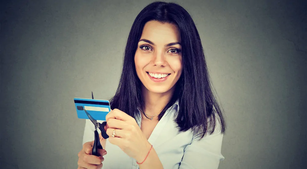 A woman cutting her credit card and smiling