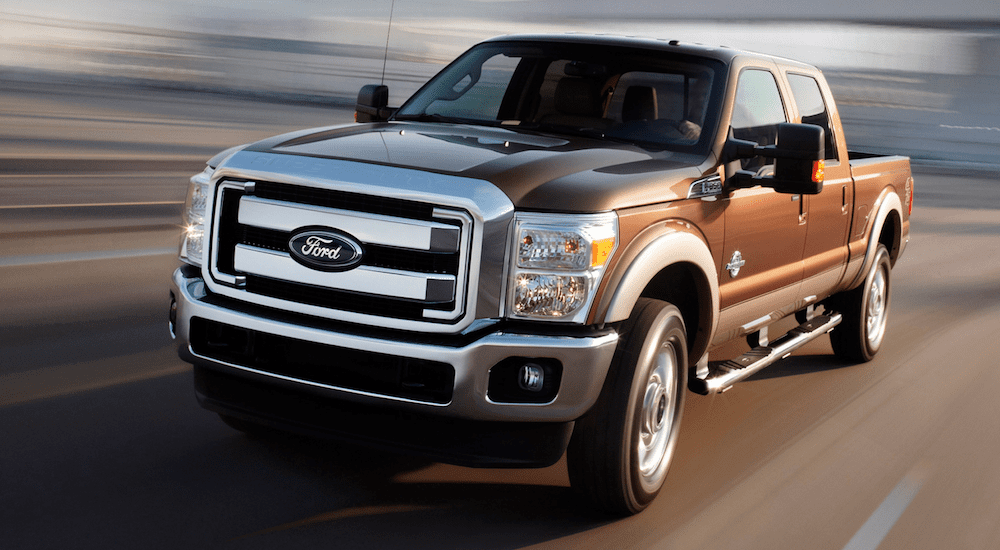 A brown 2012 Ford F250 Super Duty driving quickly