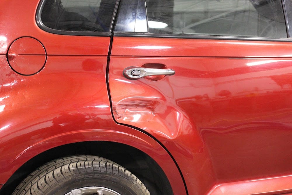 Dented Rear Quarter Panel On Red Jeep Cherokee