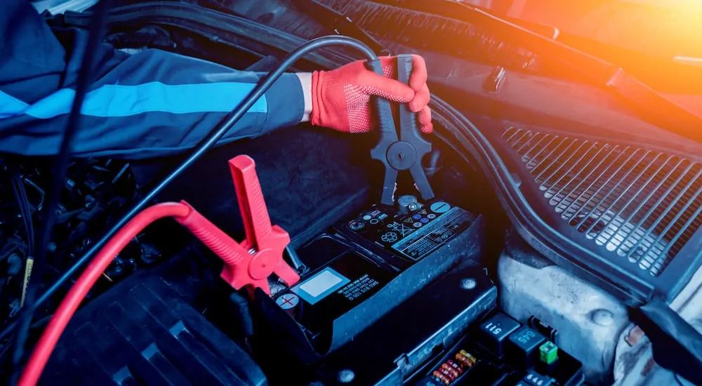 A car batter with red and black jumper cables attached