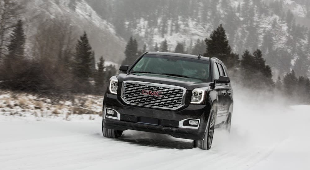 A black 2019 GMC Yukon Denali tears through a snowy path