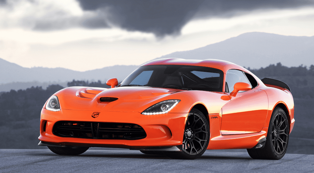 A vibrant orange 2020 Dodge Viper concept in front of dark clouds and mountains, coming to a Dodge dealership in 2020