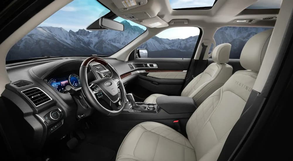 The white and black interior of a 2019 Ford Explorer Platinum with mountains out the windows