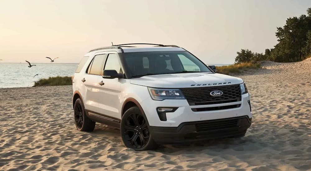 A white 2019 Ford Explorer is on a beach. Check out the 2019 updates when comparing the 2018 Ford Explorer vs 2018 Chevy Traverse.