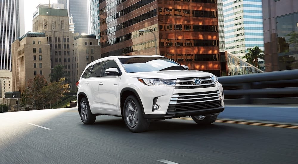White 2018 Toyota Highlander driving in city