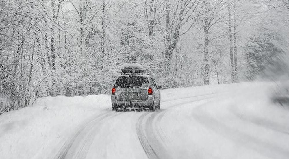 A silver Chevy SUV drives down a snowy Columbus road