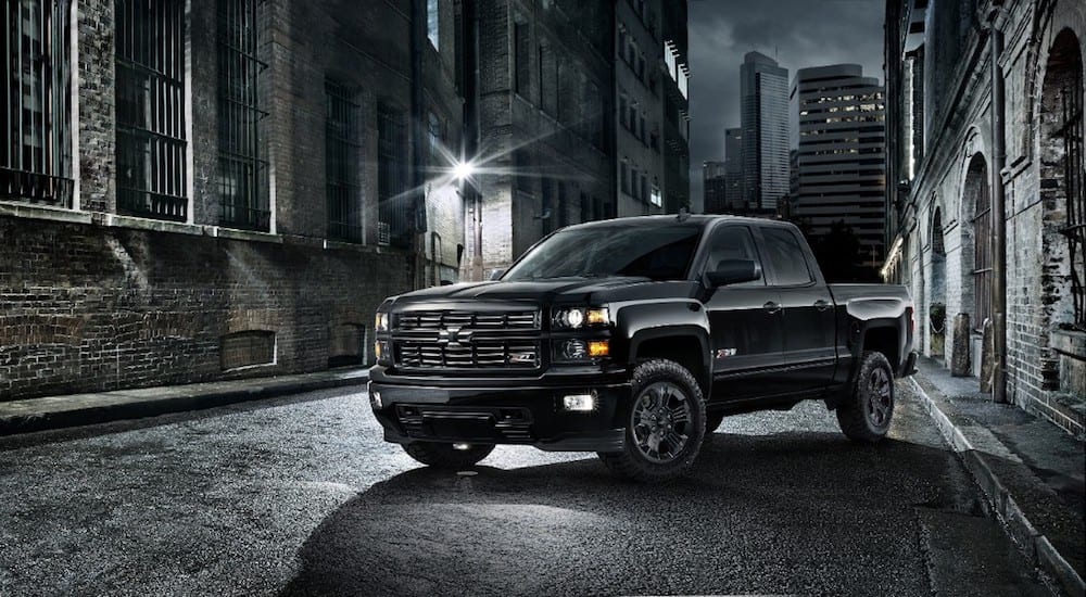 Black 2015 Chevy Silverado on city street at night