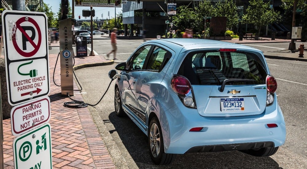 Light blue 2015 Chevy SparkEV charging on street