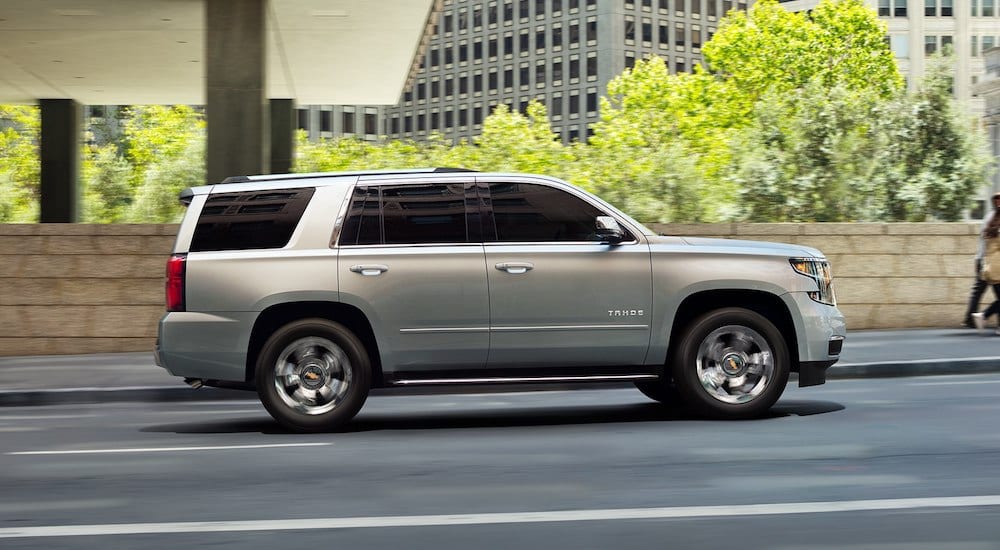 Silver 2019 Chevy Tahoe driving in city