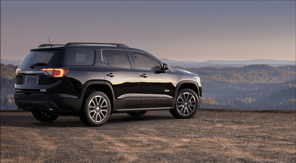 Black 2019 GMC Acadia on mountain overlooking forest