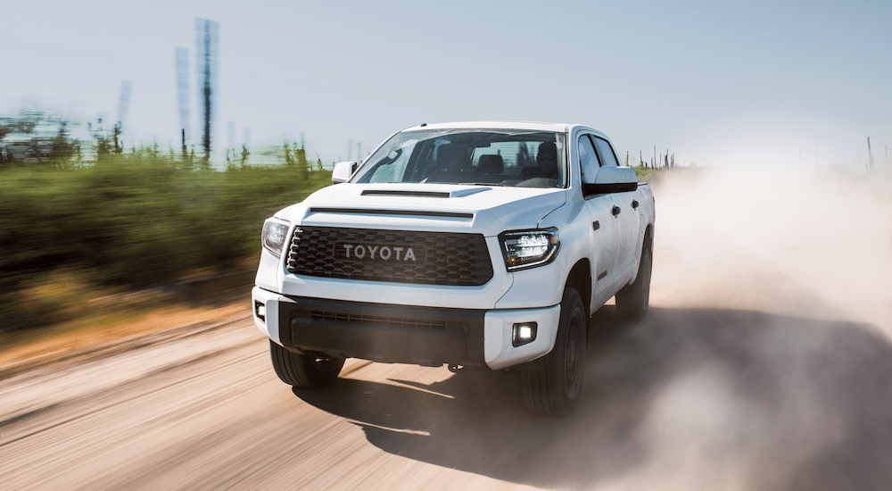 White 2019 Toyota Tundra driving in out of focus field