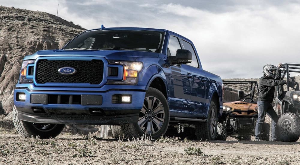Blue 2019 Ford F150 towing ATVs