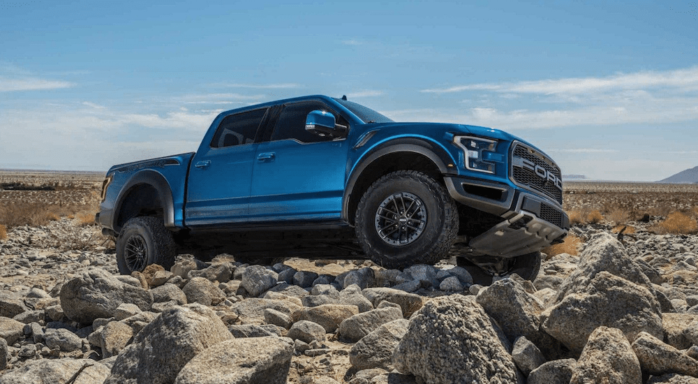 Blue 2019 Ford Raptor climbing rocks