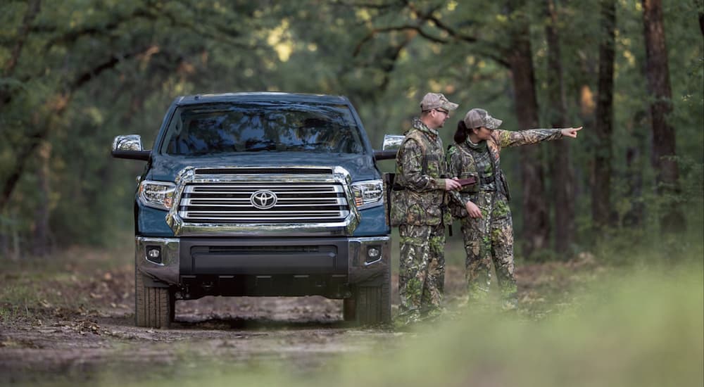 Blue 2019 Toyota Tundra in woods with two people hunting