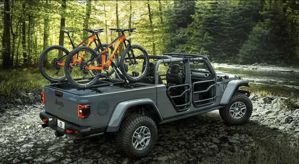 A gray 2020 Jeep Gladiator in the forest with bike rack bed accessories for off-road adventures 
