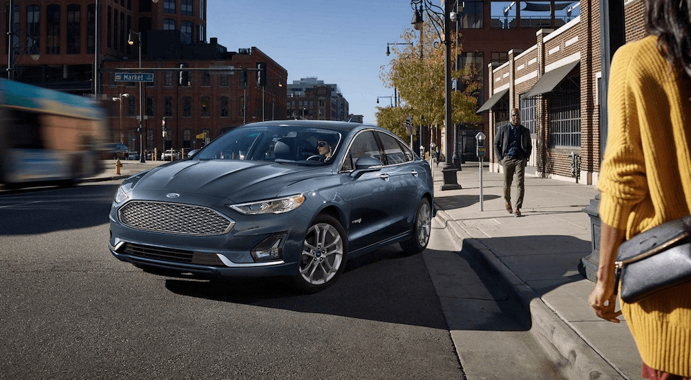 A blue 2019 Ford Fusion on a busy city street