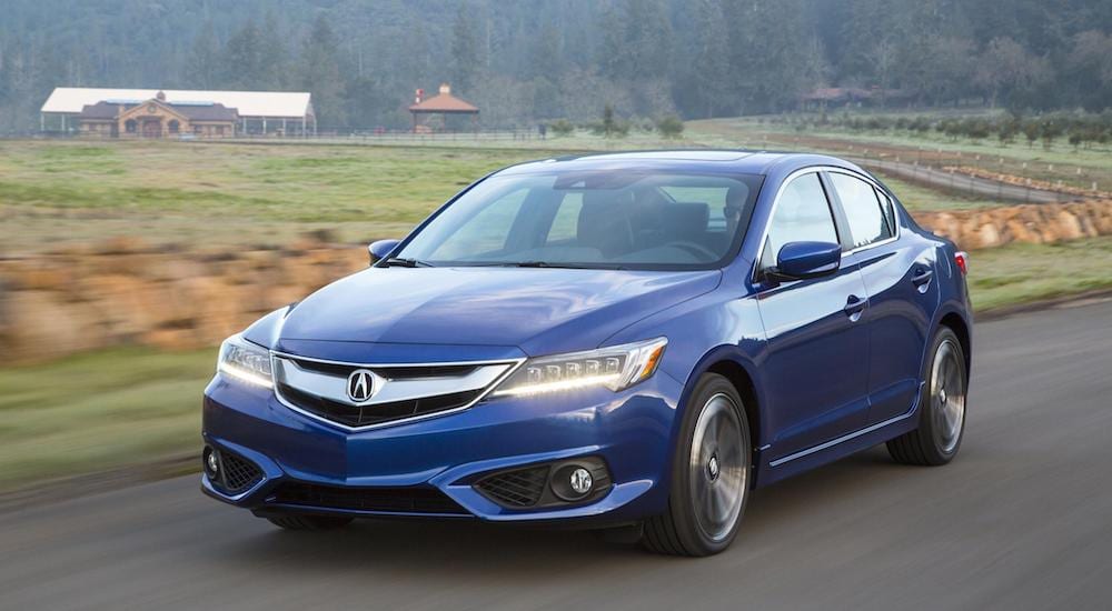 A certified pre-owned Acura ILX on a country road surrounded by farms