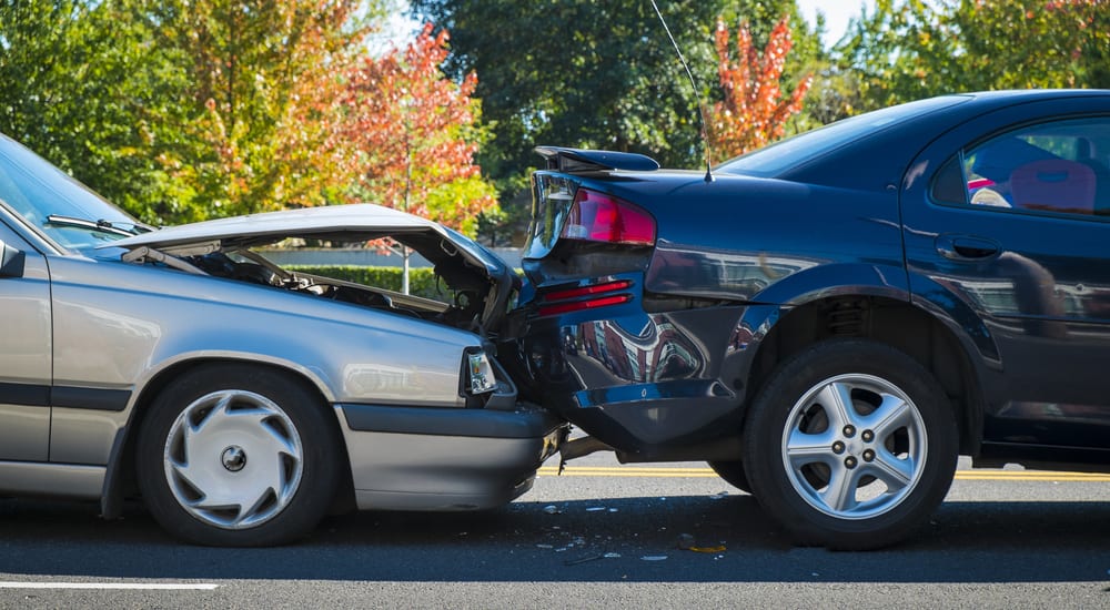 2 used cars in an accident with a silver car rear ending a black car