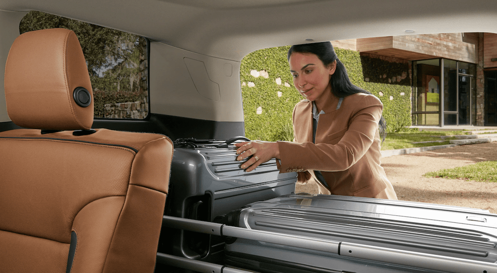 A woman loads cargo into a 2019 GMC Acadia 