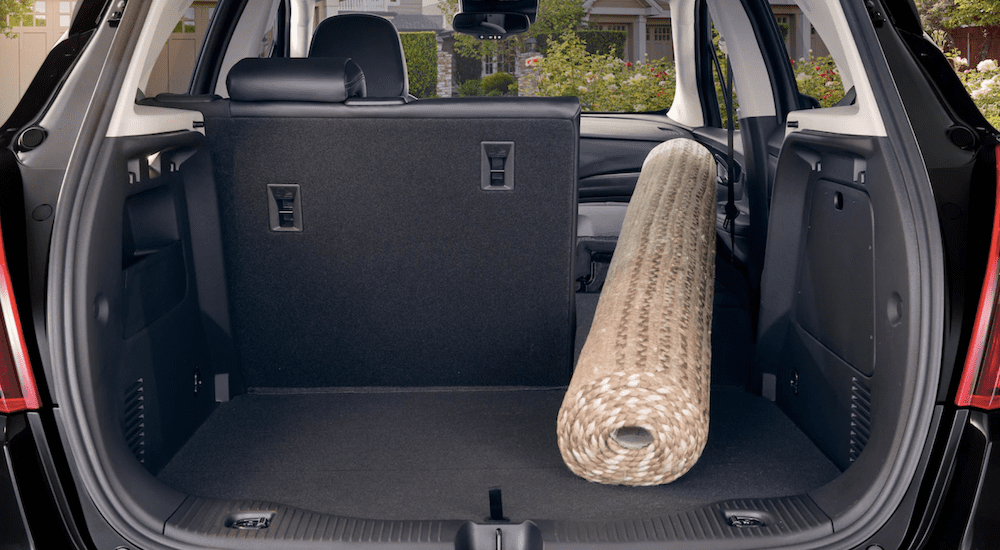 The cargo space of the 2019 Buick Encore is shown to hold a rug with the seats folded down in a comparison of the 2019 Buick Encore vs 2019 Honda HR-V.