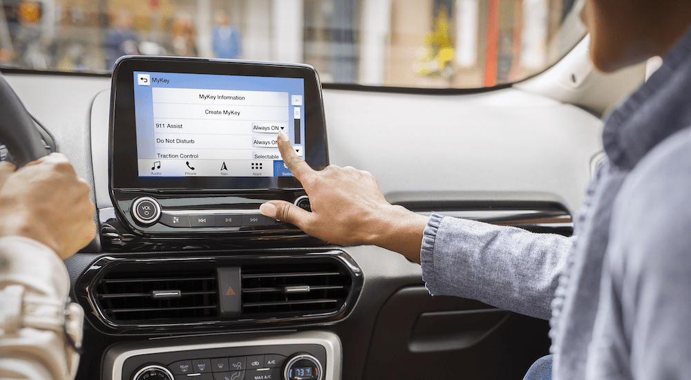 A passenger is using the touch screen in a 2019 Ford EcoSport, showing its upgraded features when comparing the 2019 Ford EcoSport vs 2019 Honda HR-V.