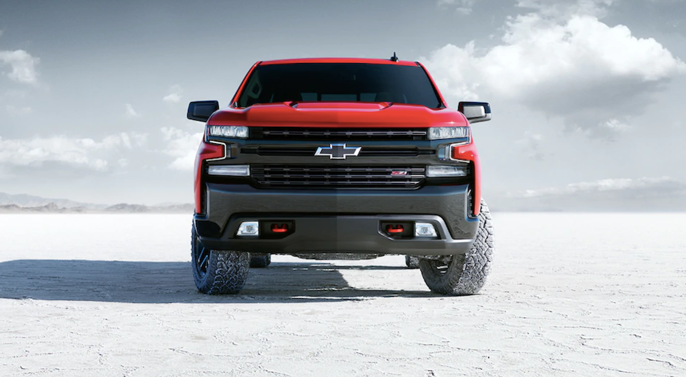 A red 2019 Chevy Silverado is parked on the salt flats with the photo taken from head on to showcase the design differences between the 2019 Chevy Silverado vs 2019 GMC Sierra.