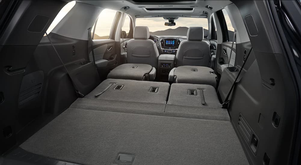 The grey interior of a 2019 Chevy Traverse shows the seats folded down. Check out cargo when comparing the 2019 Chevy Traverse vs 2019 Nissan Pathfinder.