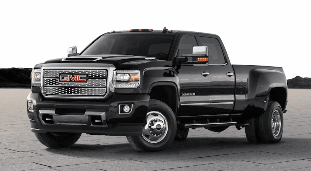 A black 2019 GMC Sierra 3500 Denali is parked in an open area.