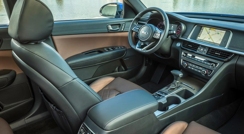 The brown and black interior of a 2019 KIA Optima is shown.