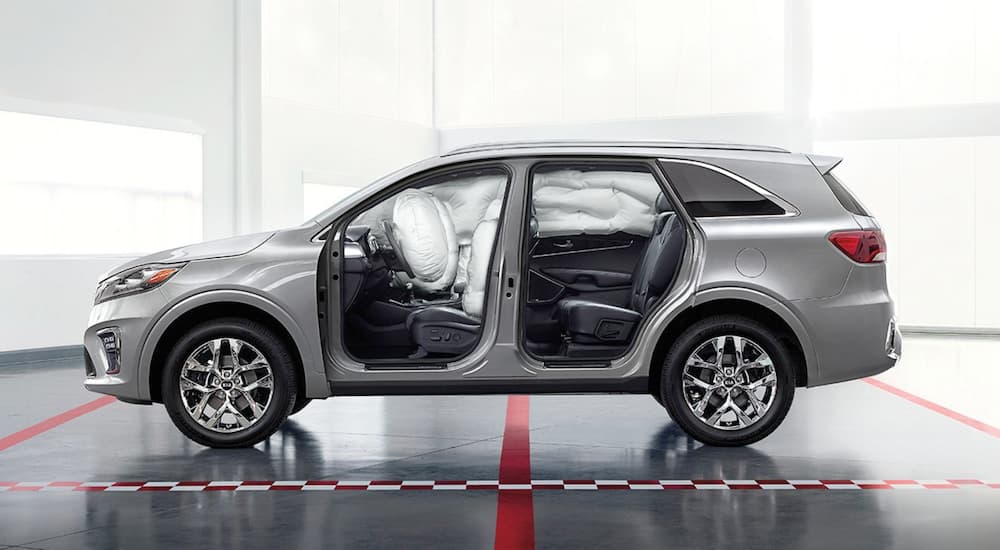 A silver 2019 KIA Sorento has the doors removed to show the deployed airbag placement.