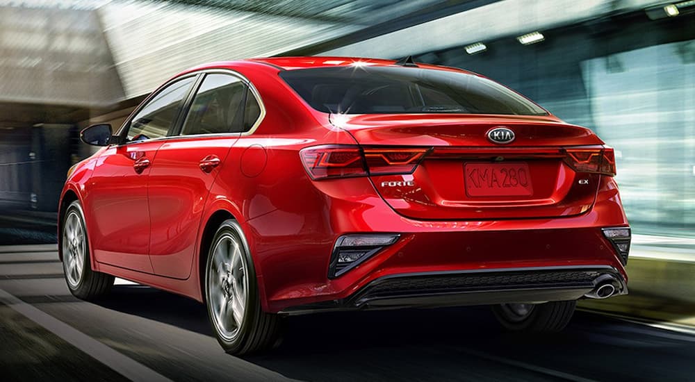 A red 2019 Kia Forte is past blurry buildings in Allentown, PA.