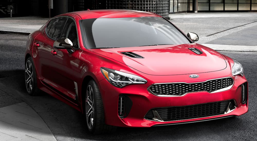 A red 2019 Kia Stinger is leaving a Kia dealership.