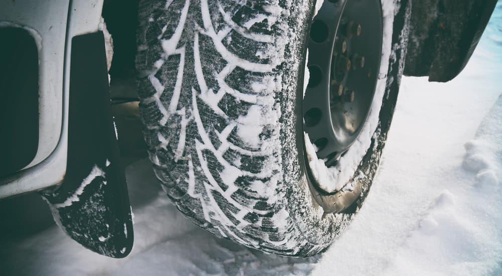 A close up is shown of snow caked into the tire tread.