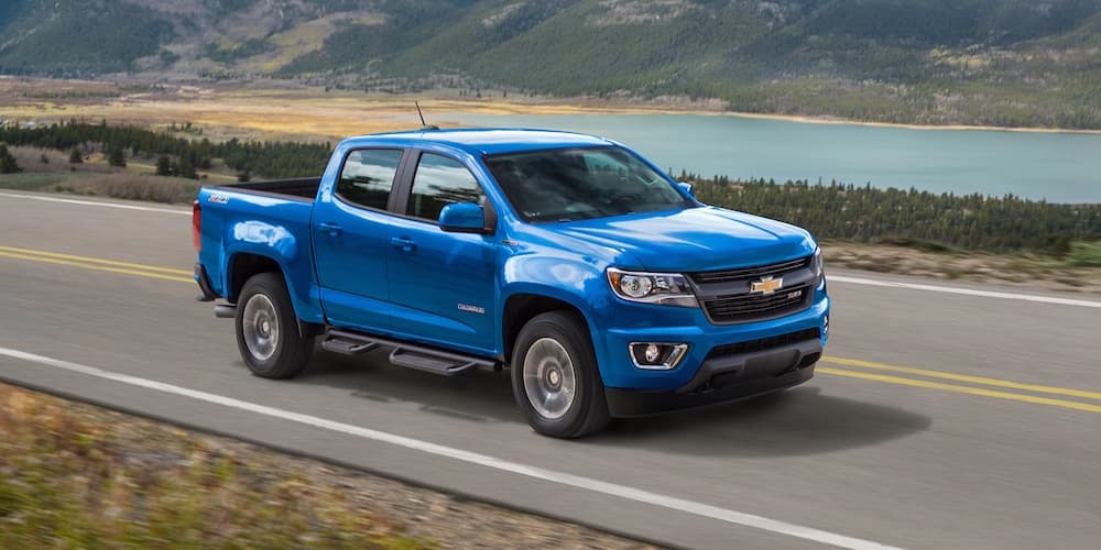 A new 2019 blue Chevy Colorado is driving down a highway. 