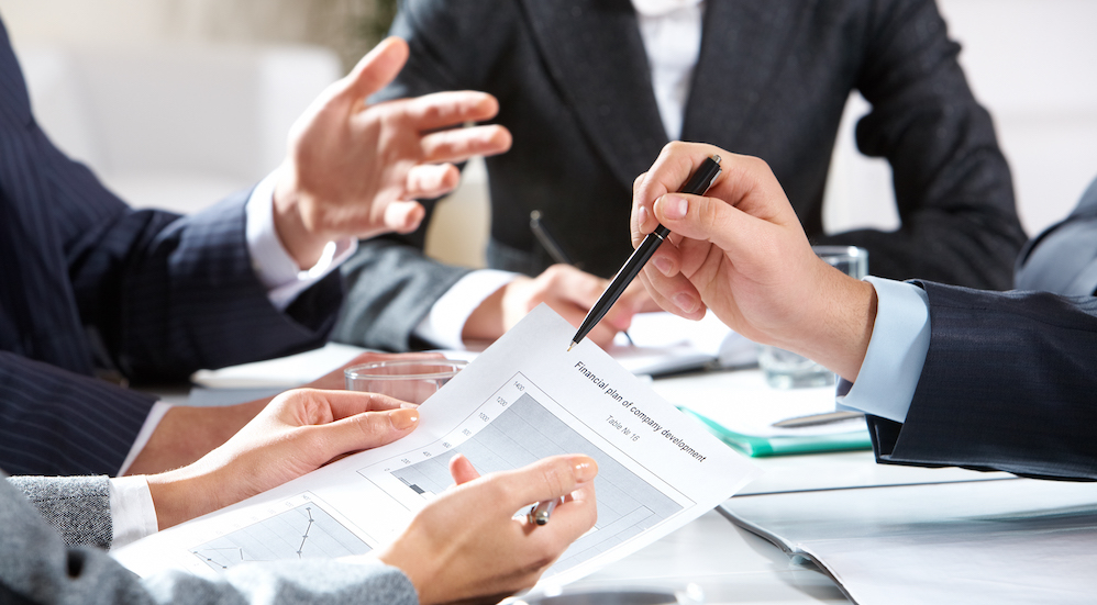 A close up of a dealership looking at finances for a customer who needs bad credit car finance is shown. 