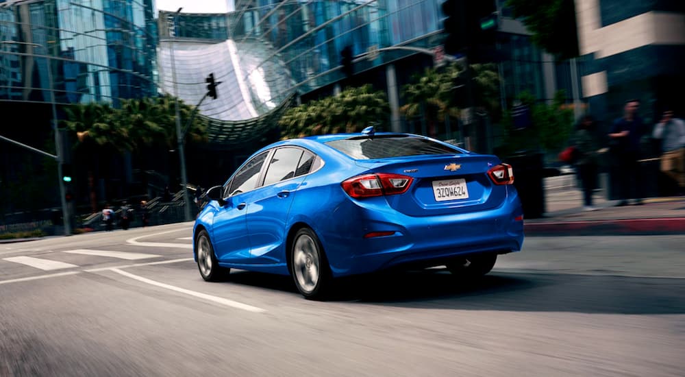 A blue 2019 Chevy Cruze is driving through a city.