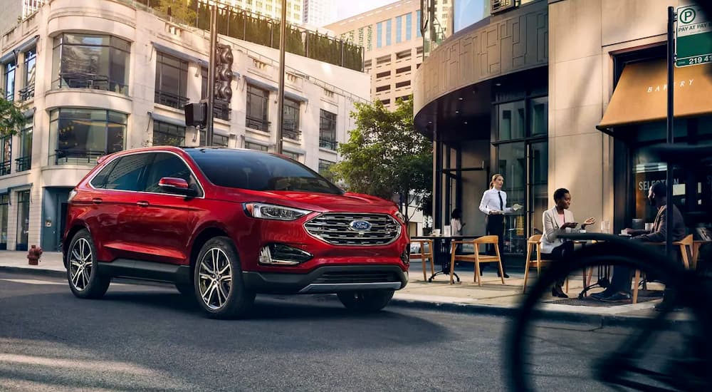 A red 2019 Ford Edge is on a busy city street.