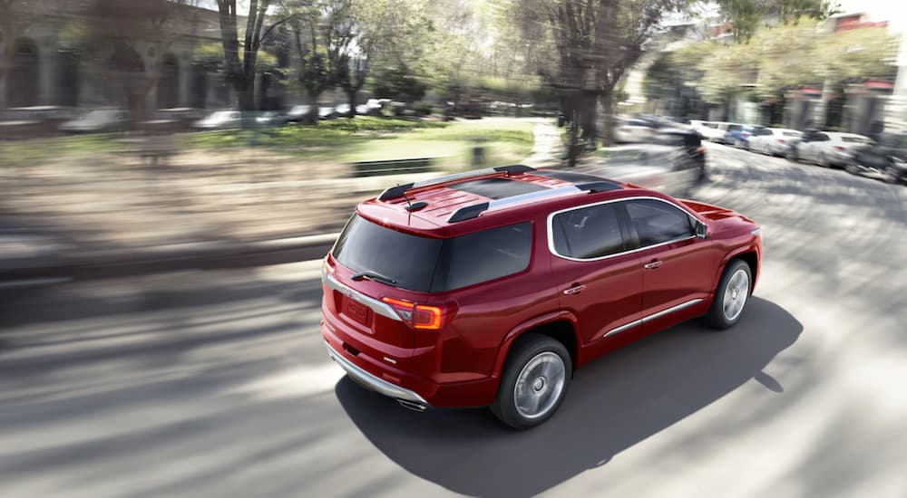 A red 2019 GMC Acadia is rounding a corner in town. Check out performance when comparing the 2019 GMC Acadia vs Jeep Grand Cherokee.