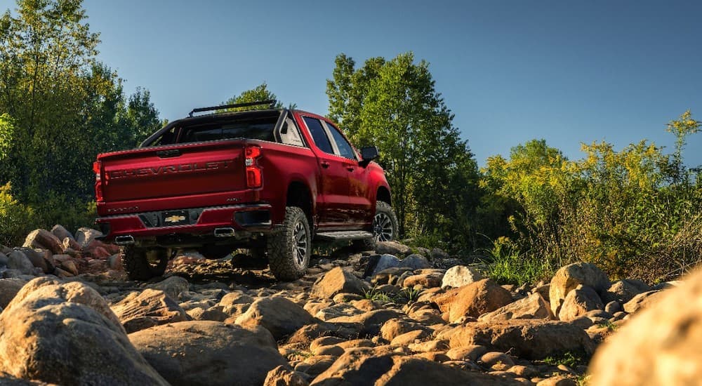 The red 2018 SEMA Chevy Silverado RST OffRoad Concept is on rough off road terrain.